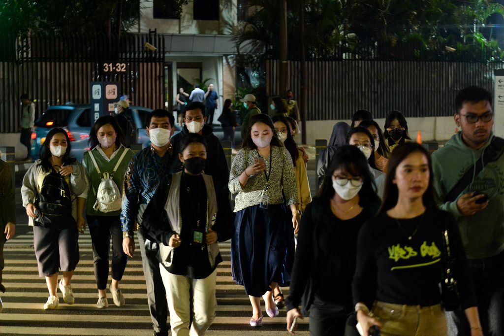 Para pekerja yang baru pulang kantor menyeberang di Jalan Jenderal Sudirman, Jakarta Pusat, saat jam pulang kerja, Selasa (9/5/2023).