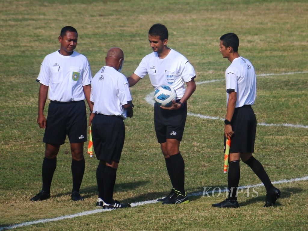 Wasit Thoriq Alkatiri (kedua dari kanan) menerima bola dari asisten wasit keempat jelang memulai laga Aceh melawan Jawa Timur, Selasa (12/10/2021), di Stadion Barnabas Youwe, Kabupaten Jayapura. Thoriq adalah satu dari tiga wasit asal Indonesia yang bertugas di Piala Dunia U-17 2023.