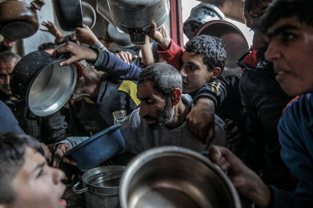 Anak-anak Palestina berebut bantuan makanan yang dibagikan di wilayah Beit Lahia, Gaza utara, 26 Februari 2024. 