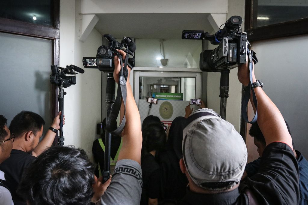 Wartawan merekam suasana sekitar ruang sidang pembacaan vonis AG (15) melalui celah pintu di Pengadilan Negeri Jakarta Selatan, Senin (10/4/2023).