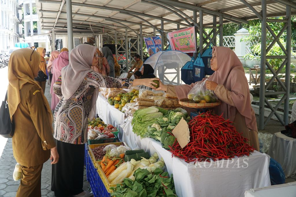 Pengunjung berbelanja di salah satu stan buah dan sayur dalam Bazar Ramadhan yang diadakan Dinas Perindustrian dan Perdagangan Sumatera Barat (Sumbar) di pelataran parkir Kantor Gubernur Sumbar, Kota Padang, Sumbar, Selasa (11/4/2023). Bazar yang digelar pada 11-14 April ini diikuti 200 peserta yang menjual produk UMKM, pakaian, bahan pokok, dan sebagainya. Bazar diharapkan bisa menekan laju inflasi di Sumbar.