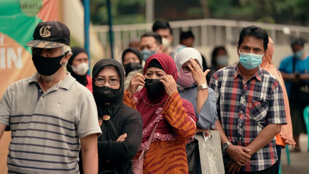 Warga antre menjalani vaksinasi penguat di Taman Swakarsa, Pondok Kelapa, Duren Sawit, Jakarta Timur, Rabu (13/7/2022). 