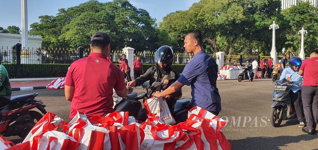 Warga menerima paket bahan pangan dari Presiden Joko Widodo di depan Istana Merdeka, Jakarta, Senin (8/4/2024).