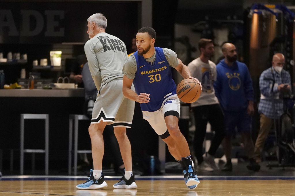 <i>Guard </i>Golden State Warriors Stephen Curry (kanan) menggiring bola melewati asisten pelatih Bruce Fraser pada sesi latihan tim di  San Francisco, Selasa (31/5/2022), 