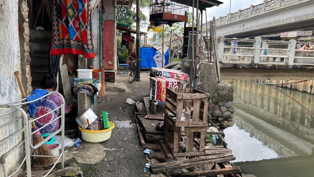 Warga Sungai Angke sedang  mencuci piring di rumahnya yang terletak di sempadan Sungai Angke, Jembatan Lima, Tambora, Jakarta Barat, Jumat (7/10/2022).