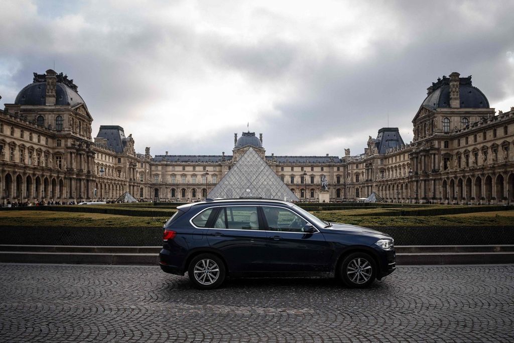 Kendaraan melintasi Museum Louvre di Paris, Perancis, Jumat (2/2/2024). 