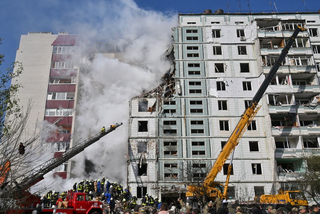 Petugas penyelamat mencari penyintas di antara reruntuhan apartemen di kota Uman, sebelah selatan Kyiv, Ukraina, 28 April 2023. Serangan rudal Rusia ke kota itu menewaskan tujuh orang.