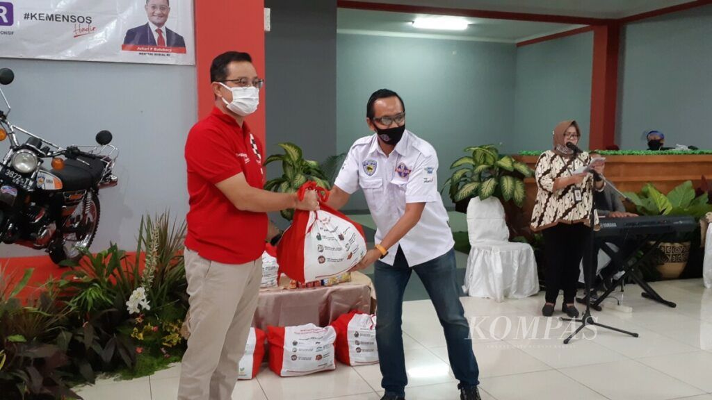 Menteri Sosial Juliari P Batubara (kiri) menyerahkan bantuan sosial kepada anggota Ikatan Motor Indonesia yang terkena dampak pandemi Covid-19, Sabtu (11/7/2020) di Jakarta.