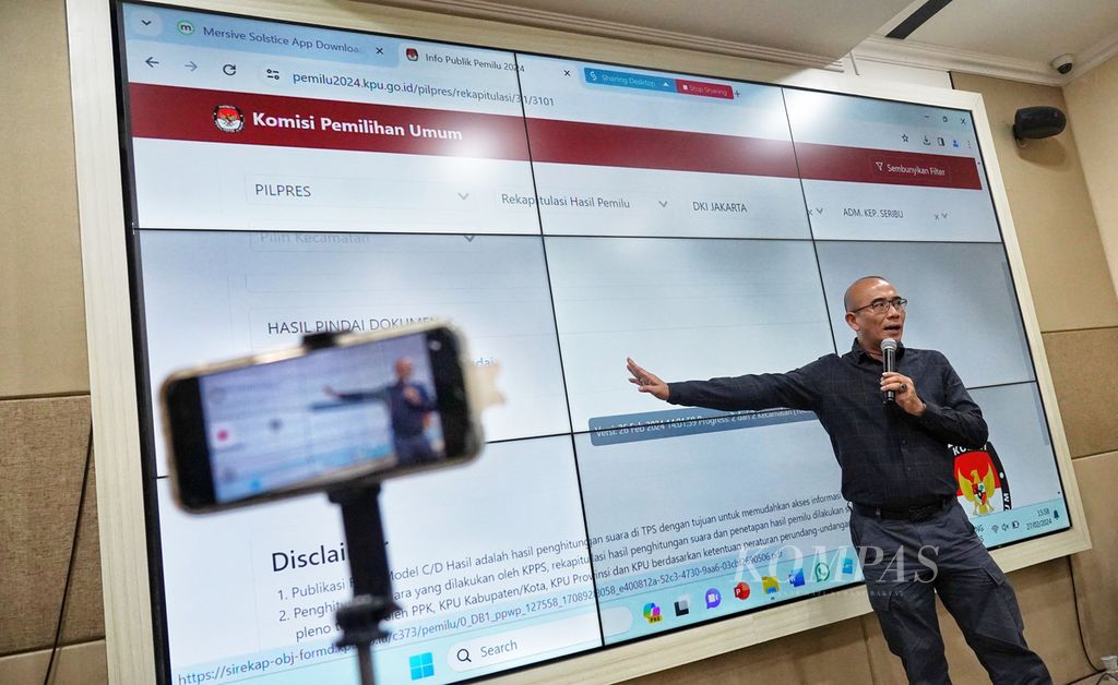 Ketua Komisi Pemilihan Umum (KPU) Hasyim Asyari menunjukkan tampilan sistem Sirekap setelah konferensi pers KPU terkait perkembangan pelaksanaan Pemilu 2024 di Media Center KPU, Jakarta, Selasa (27/2/2024).
