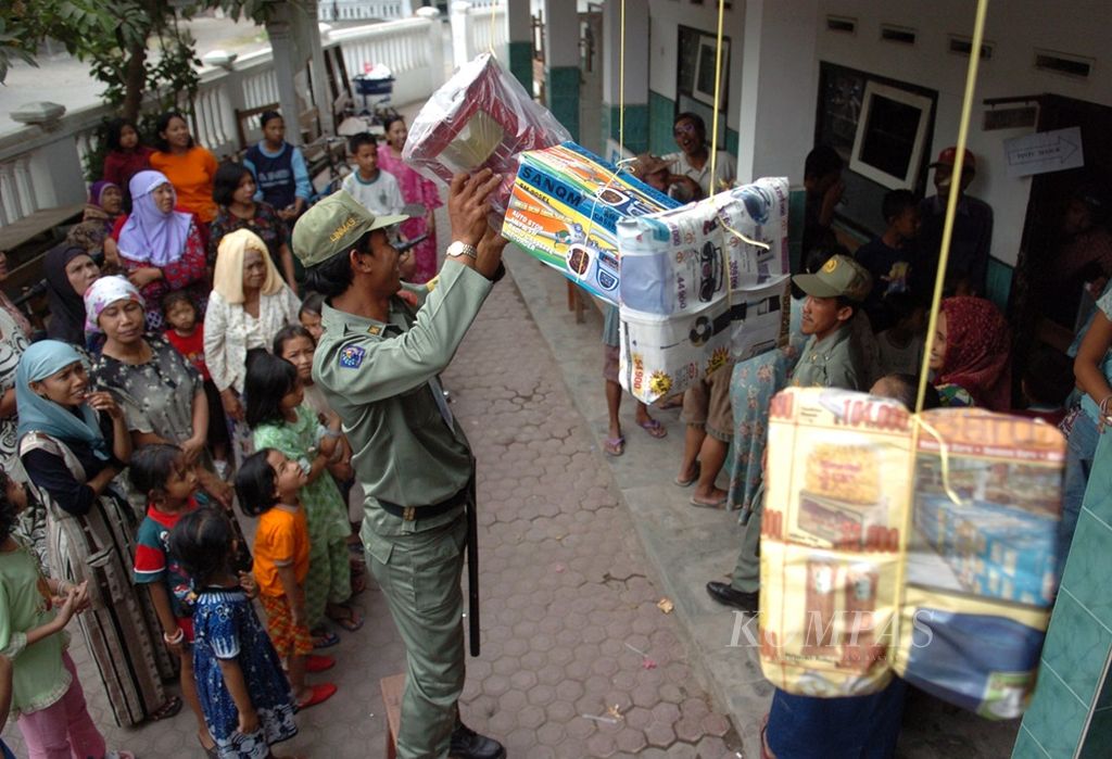 Seorang petugas keamanan TPS 1 Kelurahan Kedung Peluk, Kecamatan Candi, Sidoarjo, mengambil hadiah hadir berupa kompor setelah selesainya proses pemungutan suara di TPS tersebut dalam Pilkada Sidoarjo, Minggu (11/9/2005). 