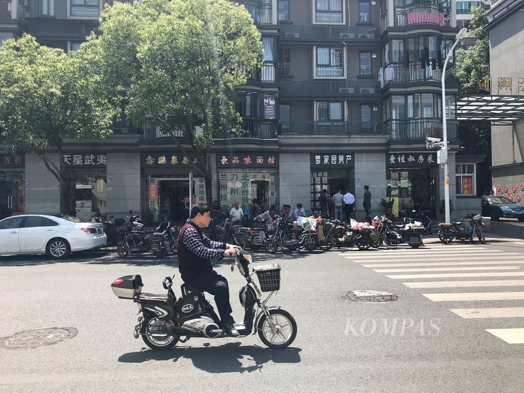 Sepeda motor listrik kini mendominasi kota-kota di China untuk mengurangi penggunaan energi fosil, seperti terlihat di kota Fuzhou, Fujian, Kamis (19/4/2018). Mereka juga mulai mengganti PLTU batubara dengan energi terbarukan, seperti energi surya.