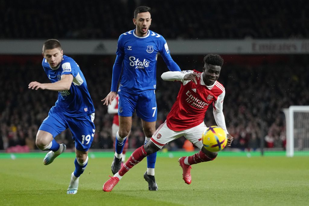 Sayap serang Arsenal, Bukayo Saka (kanan), memenangi perebutan bola dengan pemain Everton, Dwight McNeil (tengah) dan Vitaliy Mykolenko, pada laga Liga Inggris antara Arsenal dan Everton di Stadion Emirates, London, Kamis (2/3/2023) dini hari WIB.
