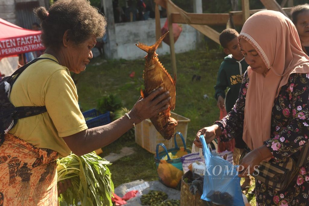  Warga yang tinggal di gunung melakukan barter sayuran dengan ikan asap produksi warga pesisir di Pasar Mambunibuni, Distrik Kokas, Kabupaten Fakfak, Papua Barat, Sabtu (20/5/2023).  