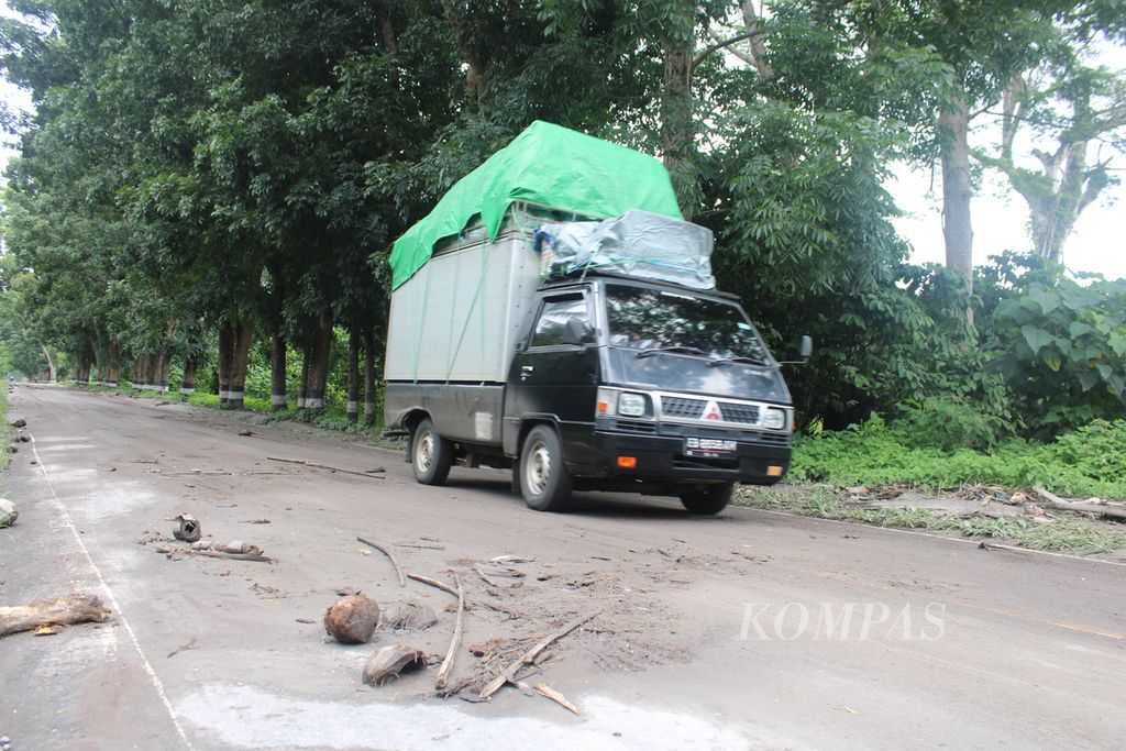 Mobilk logistik melintasi Jalan Trans-Flores, tepatnya di bawah kaki Gunung Lewotobi Laki-laki, di Kabupaten Flores Timur, Nusa Tenggara Timur, yang mengalami erupsi pada Rabu (17/1/2024). Tempat material vulkanik memenuhi badan jalan.