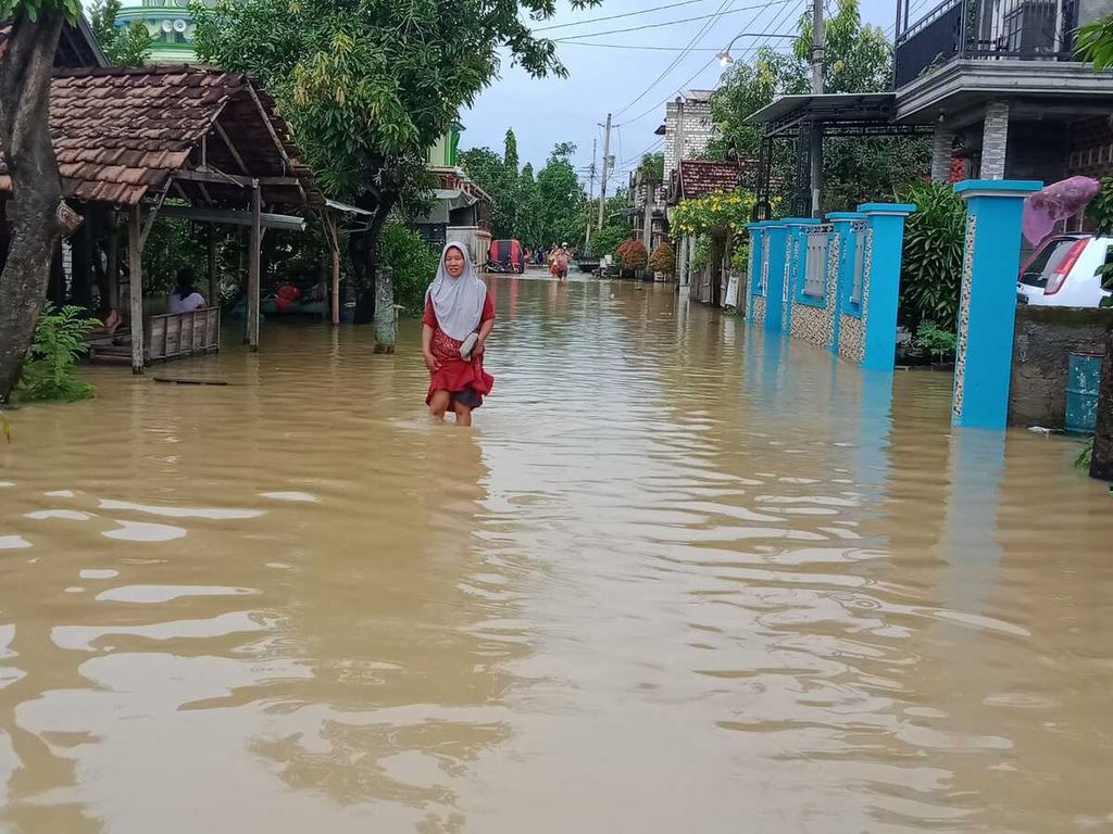 Warga beraktivitas di tengah genangan banjir di Desa Ketitang Wetan, Kecamatan Batangan, Kabupaten Pati, Jawa Tengah, Kamis (10/3/2022).