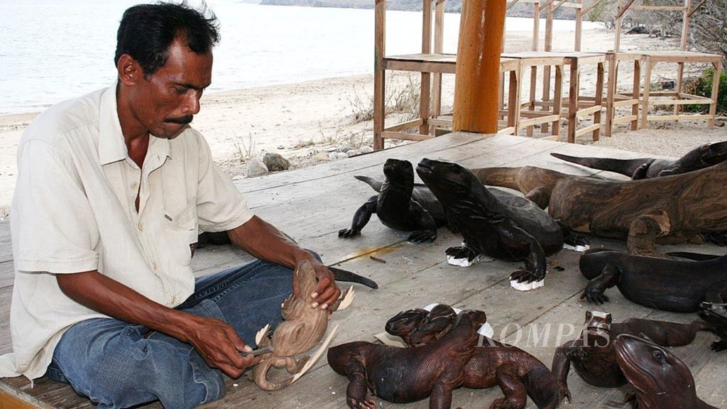 Rahali, warga Desa Komodo, di Pulau Komodo, Kabupaten Manggarai Barat, Nusa Tenggara Timur (NTT), membuat patung komodo, Selasa (2/10/2017). Patung dari ukuran terkecil hingga yang paling besar dijual dengan harga Rp 25.000-Rp 700.000 per patung.