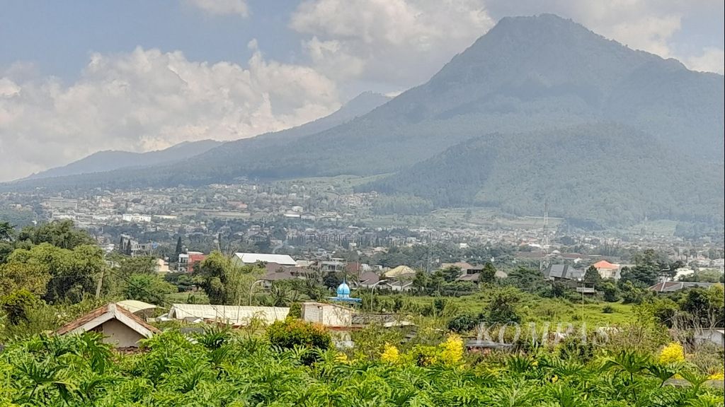 Panorama Kota Batu di Jawa Timur yang berada di sisi kiri kaki Gunung Panderman terlihat dari kejauhan dengan latar muka kebun tanaman hias di Desa Sidomulyo, Kecamatan Bumiaji, Senin (11/4/2022).