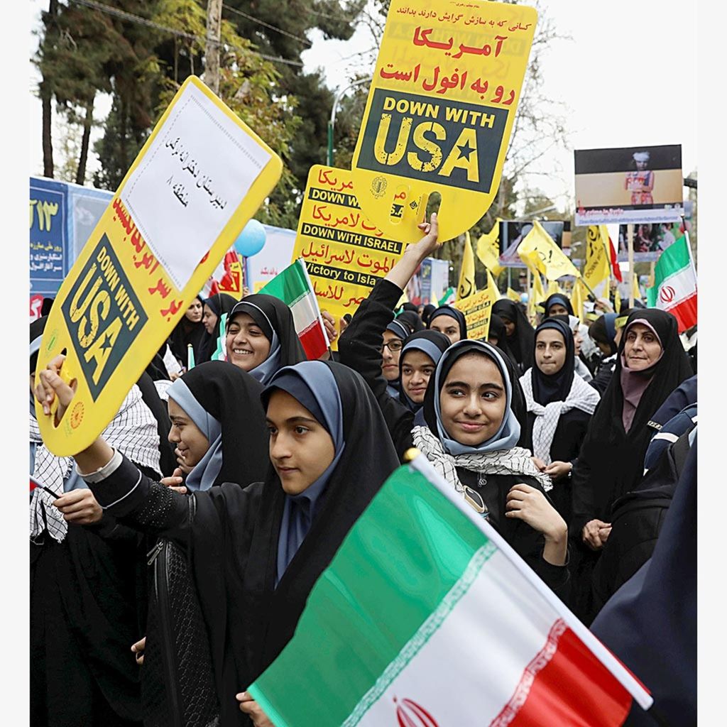 Para siswa memegang bendera nasional Iran dan poster anti-AS dalam unjuk rasa tahunan di depan bekas Kedutaan Besar AS di Teheran, Iran, Senin (4/11/2019). Pasca-penarikan diri AS dari perjanjian nuklir Iran 2015 dan penerapan sanksi AS terhadap Iran, situasi di kawasan Teluk kembali menghangat.