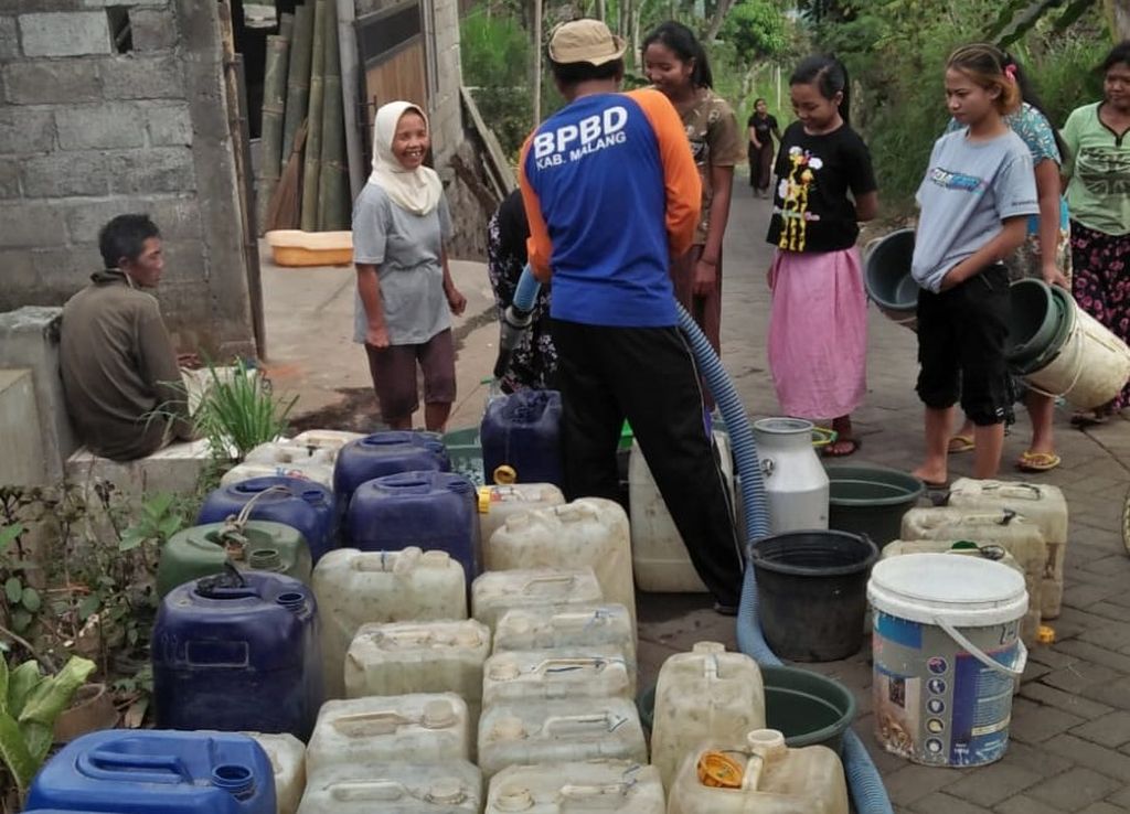 Petugas Badan Penanggulangan Bencana Daerah Kabupaten Malang, Jawa Timur, melakukan <i>dropping</i> air bersih kepada warga di Desa Klampok, Kecamatan Singosari, Kabupaten Malang, Minggu (10/9/2023).