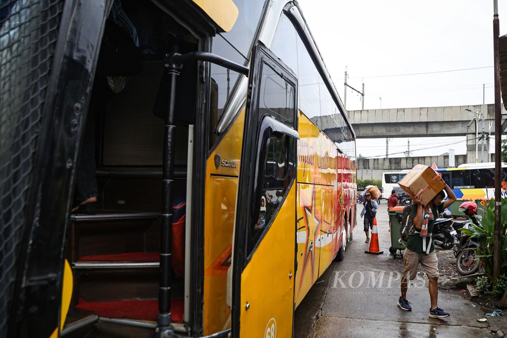 Penumpang memanggul kardus yang akan dibawa ke bagasi bus di Terminal Lebak Bulus, Jakarta Selatan, Jumat (29/3/2024).
