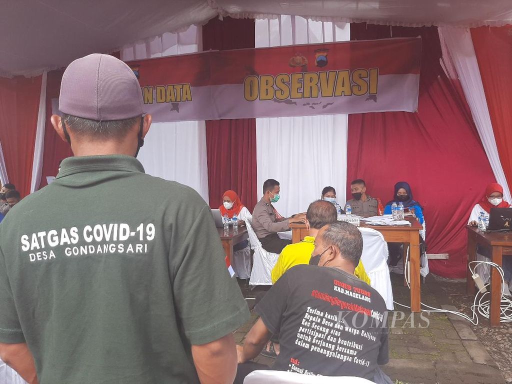 Salah seorang petugas dari Satuan Tugas Penanganan Covid-19 dari salah satu desa di Kabupaten Magelang mengawasi pelaksanaan vaksinasi serentak yang dilakukan di Taman Wisata Candi Borobudur, Jumat (18/2/2022).