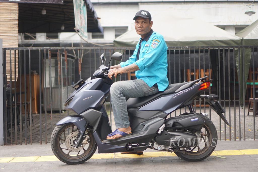 Sunarto (51), pria asal Boyolali, Jawa Tengah, berpose di atas motornya di kawasan Blok M, Jakarta, Selasa (2/4/2024). Ia adalah juru parkir di depan kantor Peruri.