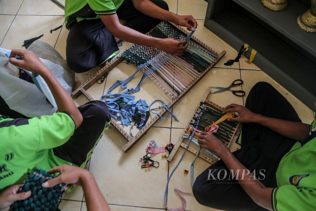 Tangan anak-anak binaan membuat kain lap dari limbah kain di Lembaga Pembinaan Khusus Anak (LPKA) Kelas I Tangerang, Banten, Rabu (23/8/2023).  