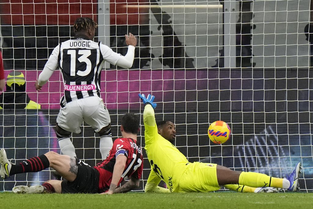 Pemain Udinese, Iyenoma Udogie (kiri), mencetak gol penyama kedudukan dalam pertandingan Liga Italia antara AC Milan dan Udinese di Stadion Giuseppe Meazza, Milan, Sabtu (26/2/2022) dini hari WIB. Pertandingan berakhir imbang, 1-1.
