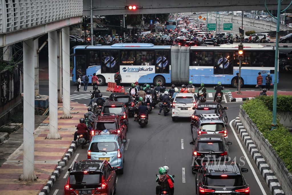 Kepadatan lalu lintas di persimpangan jalan di kawasan Kuningan, Jakarta, Senin (3/7/2023). Bekerja sama dalam Project Green Light dengan Google, Dinas Perhubungan DKI Jakarta telah memasang teknologi kecerdasan buatan atau <i>artificial intelligence</i> di 20 simpang jalan sejak April 2023.