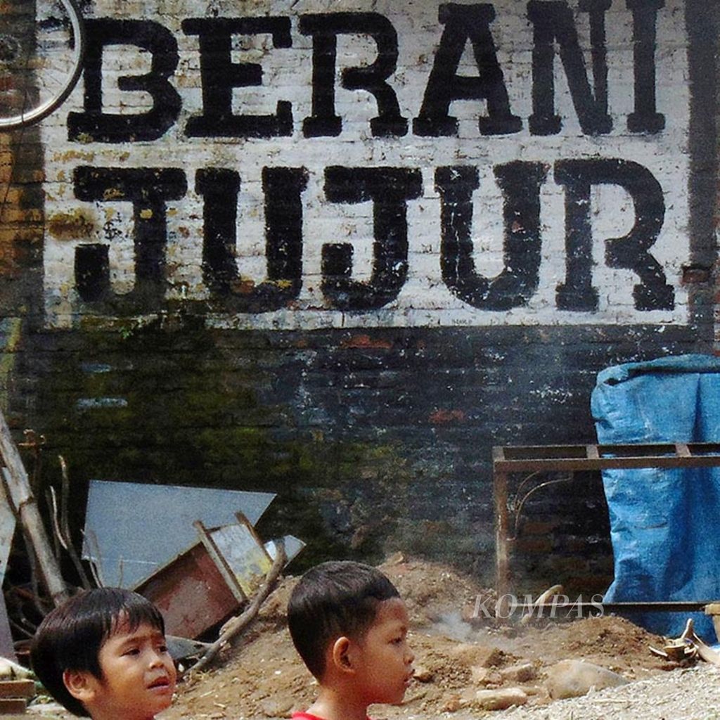 Dua anak di Pondok Pesantren Buntet, Kabupaten Cirebon, Jawa Barat, melintasi mural berisi ajakan berani jujur, Minggu (5/2/2017). Sifat berani jujur dibutuhkan bangsa ini di tengah maraknya korupsi di lembaga pemerintah hingga lembaga peradilan. 