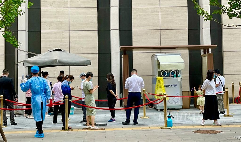 Warga mengantre untuk tes swab antigen di depan perkantoran di Beijing, ibu kota China, Jumat (12/8/2022).