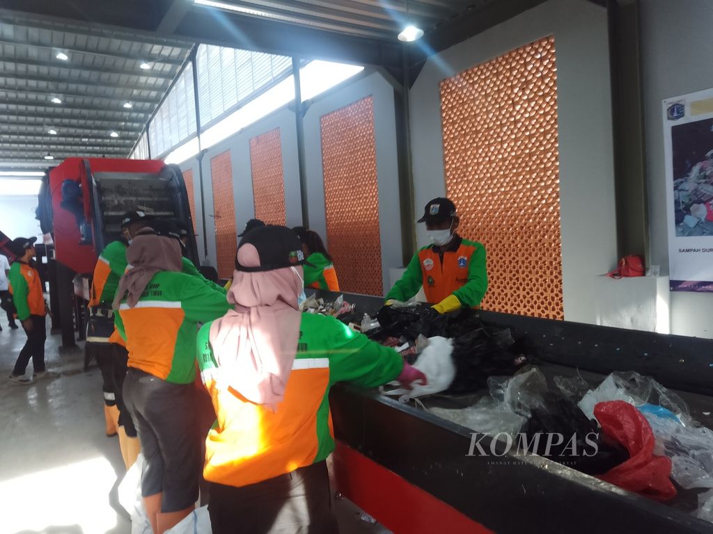 Sejumlah pegawai sedang memilah sampah di tempat pengolahan sampah reduce-reuse-recycle (TPS3R) di dua tempat yakni Ciracas Jakarta Timur, Jumat (26/1/2024). Pemilahan sampah ini merupakan tahap awal pemrosesan sampah untuk diubah menjadi bahan bakar alternatif dan pupuk kompos.