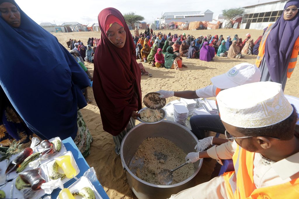 Lembaga swadaya masyarakat lokal menyiapkan makanan berbuka puasa untuk para pengungsi di kamp pengungsi di pinggiran Mogadishu, Somalia, Jumat (24/3/2023). Bulan suci Ramadhan Maret lalu itu bertepatan dengan kekeringan terpanjang yang pernah terjadi di Somalia. 