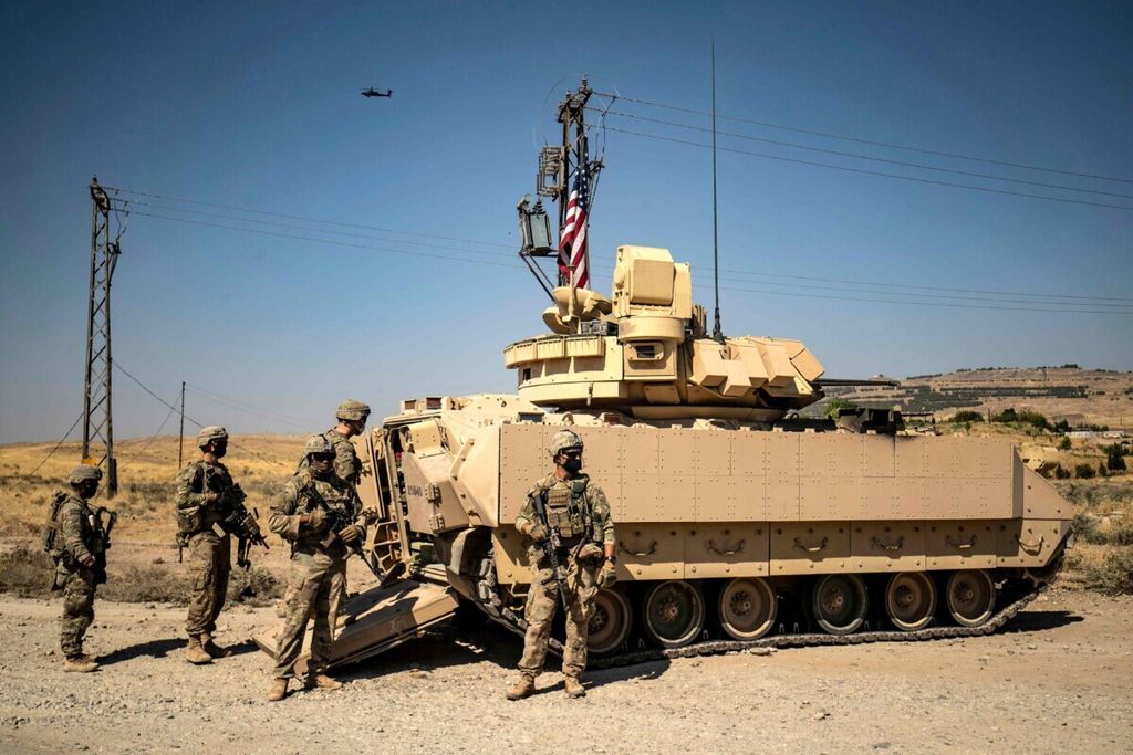Tentara Amerika Serikat berdiri di samping kendaraan militer dekat blok minyak Rmeilan di wilayah Suriah yang dikuasai kelompok Kurdi di Provinsi Hasakeh bagian timur laut di Suriah, 5 Oktober 2020. 