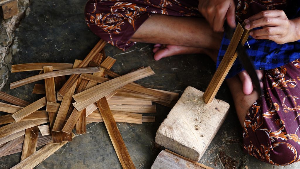Tangan Masyitoh (24) saat membuat bilah-bilah untuk dianyam dalam pembuatan keranjang besek bambu untuk ikan pindang oleh warga di Kampung Pasir Pogor, Cijeruk, Kabupaten Bogor, Jawa Barat, Rabu (24/2/2021). Tingginya permintaan pasar akan kebutuhan ikan pindang pun menggerakkan sektor ekonomi warga setempat yang rata-rata menambah penghasilan sebagai perajin besek bambu, selain menjadi petani dan peladang. Setiap pekan rata-rata perajin mampu memproduksi sekitar 5.000 besek bambu wadah ikan ini. Mereka jual dengan harga Rp 150 per unit kepada pengepul yang memenuhi kebutuhan wadah ini untuk pegiat usaha pemindangan ikan di Bogor, Depok, dan Jakarta. 