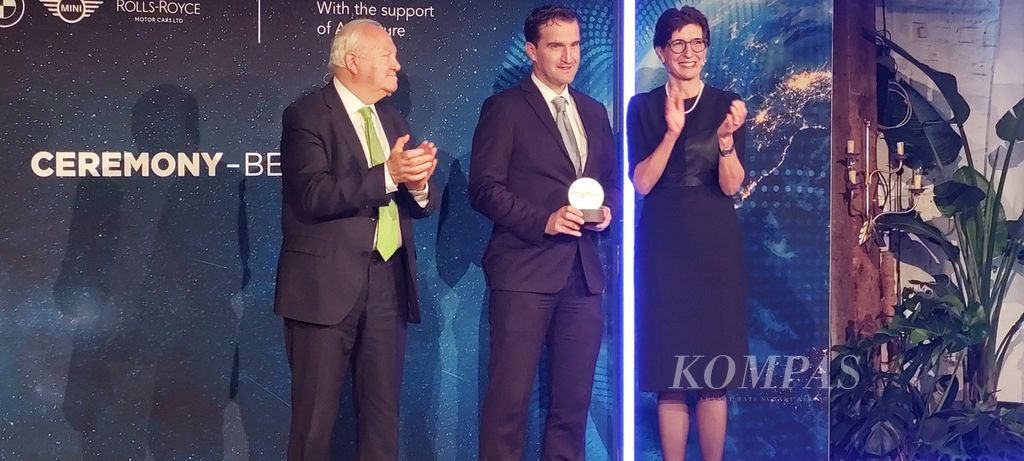 Jonathan Hamilton (center) is flanked by Migel Angel Moratinos (UNAOC) and Ilka Horstmeier, Member of the Board of Management of BMW AG, Human Resources, Labour Relations Director, as they receive the trophy for the Intercultural Innovation Hub (IIH) 2023 in Berlin, Germany, on Wednesday night (5/24/2023).