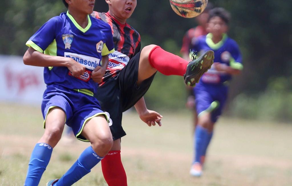 Pemain SSB Bina Taruna Adhitya Estu Firmansyah (merah-hitam) berebut bola dengan pemain SSJ Kota Bogor Galuh Arahman Malik dalam laga pekan ke enam Liga Kompas Gramedia Panasonic U-14 di Stadion GOR Ciracas, Jakarta Timur, Minggu (17/9). SSB Bina Taruna menang 5-0.
