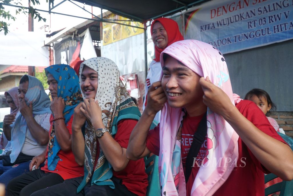 Kalangan bapak-bapak mengikuti lomba memasang kerudung dalam peringatan Hari Ulang Tahun Kemerdekaan Ke-78 Republik Indonesia di RT 003 RW 005, Kelurahan Dadok Tunggul Hitam, Kota Padang, Sumatera Barat, Kamis (17/8/2023).