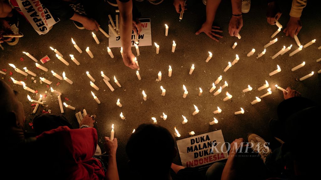 Football lovers light candles at the entrance of Asia Africa, Gelora Bung Karno Stadium, Jakarta, Sunday (2/10/2022) night. They held a flower-laying event, lit 1,000 candles and prayed together to honor Aremania who was the victim of the Kanjuruhan Tragedy after Arema FC's match against Persebaya Surabaya.