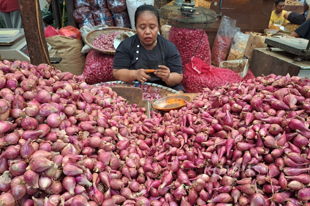 Pedagang sedang mengupas bawang merah di Pasar Induk Kramat Jati, Jakarta Timur, Jakarta, Selasa (26/12/2023). Harga bawang di pasar ini naik dari Rp 35.000 per kilogram sebelum Natal menjadi Rp 40.000 per kilogram.