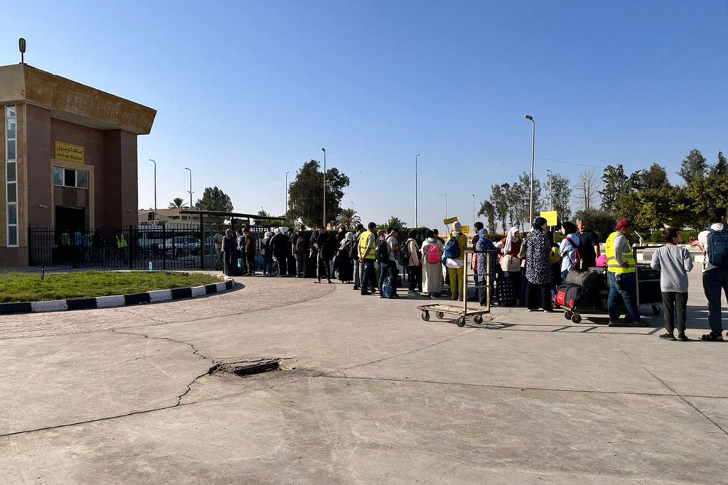 Warga menyeberang gerbang perbatasan Rafah di Mesir, yang berbatasan langsung dengan Jalur Gaza, Kamis (9/11/2023). 