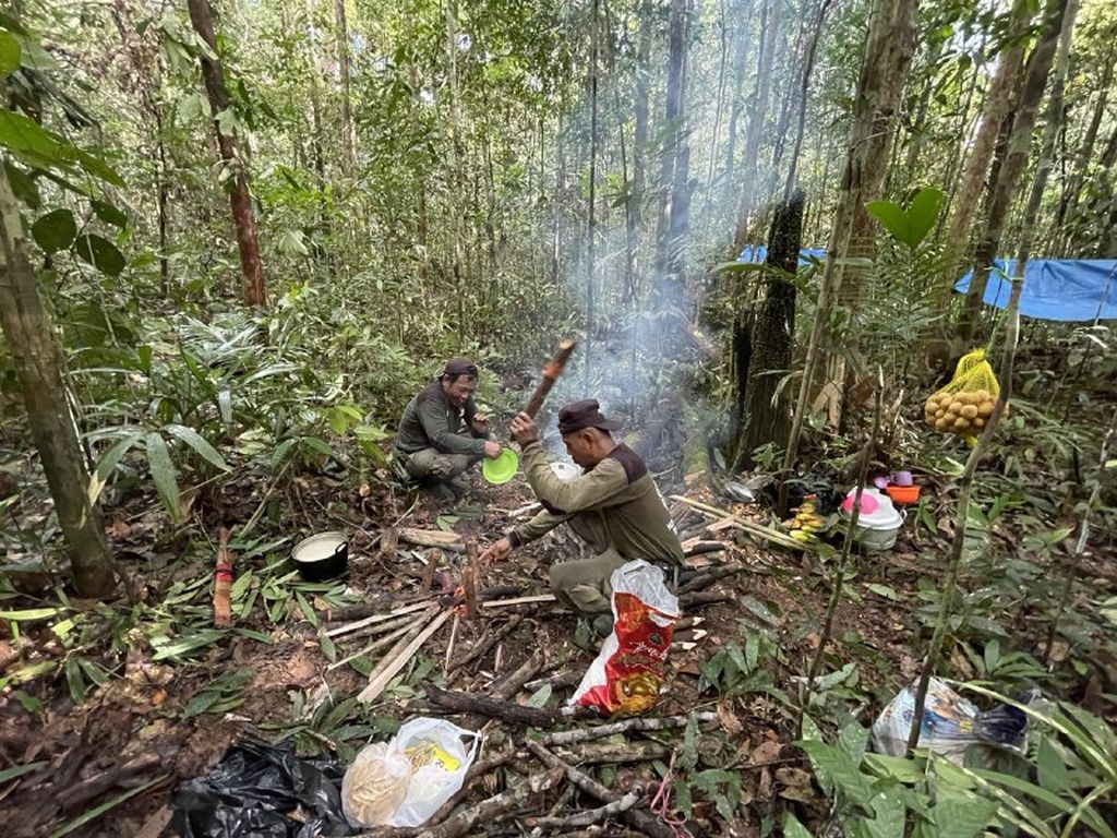 Para penjaga Hutan Lindung Sungai Wain, Kota Balikpapan, Kalimantan Timur, sedang memasak di sela-sela kegiatan patroli rutin, Sabtu (4/2/2023).