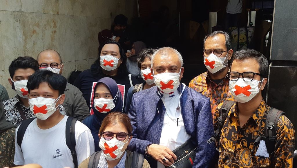 Pihak terlapor dugaan fitnah oleh Menteri Koordinator Bidang Kemaritiman dan Investasi Luhut Binsar Pandjaitan dan para pendukungnya mengenakan "Masker Pembungkaman" sebagai bentuk protes kebebasan berpendapat, di Polda Metro Jaya, Jakarta, Kamis (21/10/2021).