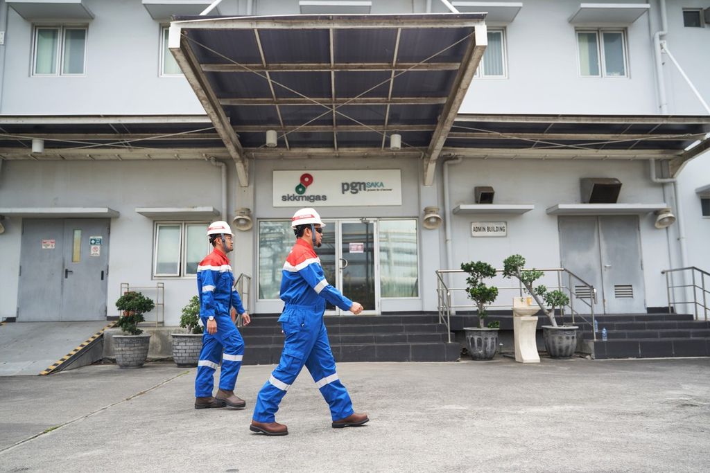 Dua pekerja melintas di kantor Saka Energi, di kawasan industri Manyar, Gresik, Jawa Timur (27/11/2023).