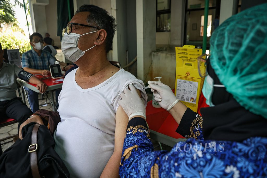 Tenaga kesehatan menyuntikkan vaksin kepada warga di kantor Dinas Kesehatan DKI Jakarta, Selasa (19/12/2023). Pemerintah Provinsi DKI Jakarta mulai memberikan vaksin dosis kelima berjenis Inavac untuk memperkecil potensi penularan SARS-CoV-2 penyebab Covid-19. Melalui Dinas Kesehatan, Pemprov DKI Jakarta menyediakan sentra vaksinasi yang tersebar di 44 lokasi.  