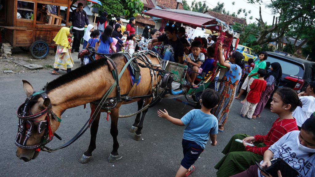 Anak-anak warga di Kebon Kelapa, Bogor Tengah, Kota Bogor, Jawa Barat, saat antre bergiliran untuk naik delman (27/4/2021). Hiburan berkeliling naik delman menjadi bagian kebiasaan anak-anak setempat untuk mengisi waktu Ngabuburit atau menunggu tiba waktu berbuka puasa dengan membayar Rp 2.000 per keliling yang menempuh rute sekitar perumahan warga. T1