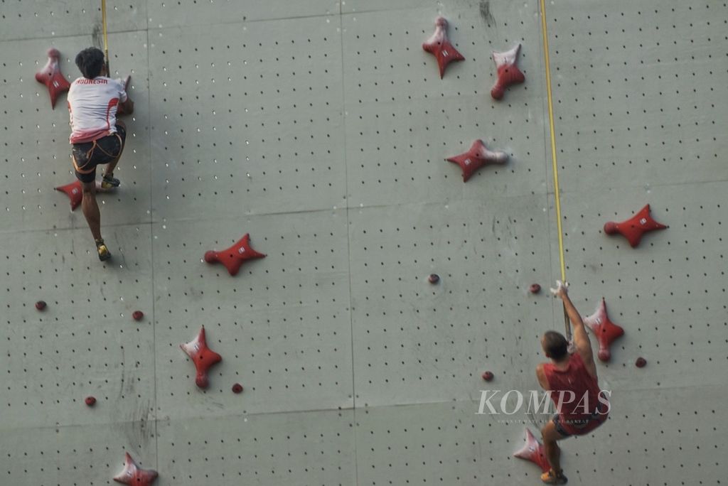 Atlet panjat tebing nomor <i>speed</i> Indonesia, Rahmad Adi Mulyono (kiri) dan Aspar, beradu kecepatan saat latihan di Hotel Santika Premiere, Bekasi, Sabtu (13/7/2024). Rahmad mewakili Indonesia di Olimpiade Paris 2024.