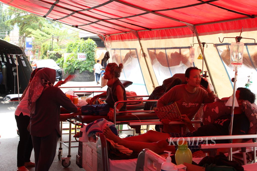 Sejumlah pasien Rumah Sakit Umum Daerah Sumedang bertahan di tenda darurat yang dipasang di depan rumah sakit, Senin (1/1/2024). Para pasien dirawat secara darurat di luar RS pascagempa melanda daerah ini sehari sebelumnya.