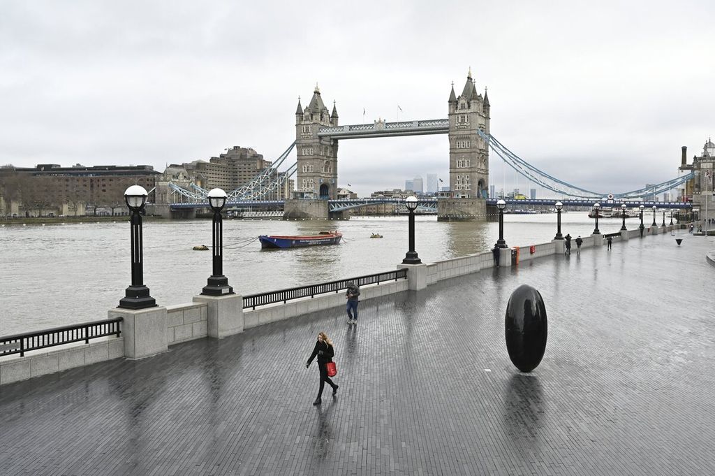 Sejumlah warga terlihat berjalan di sepanjang tepi Sungai Thames dengan latar belakang Tower Bridge di London, Inggris, 12 Januari 2021. Tepian Sungai Thames merupakan salah satu tempat favorit Pangeran Naruhito saat kuliah di Inggris, 40 tahun silam.