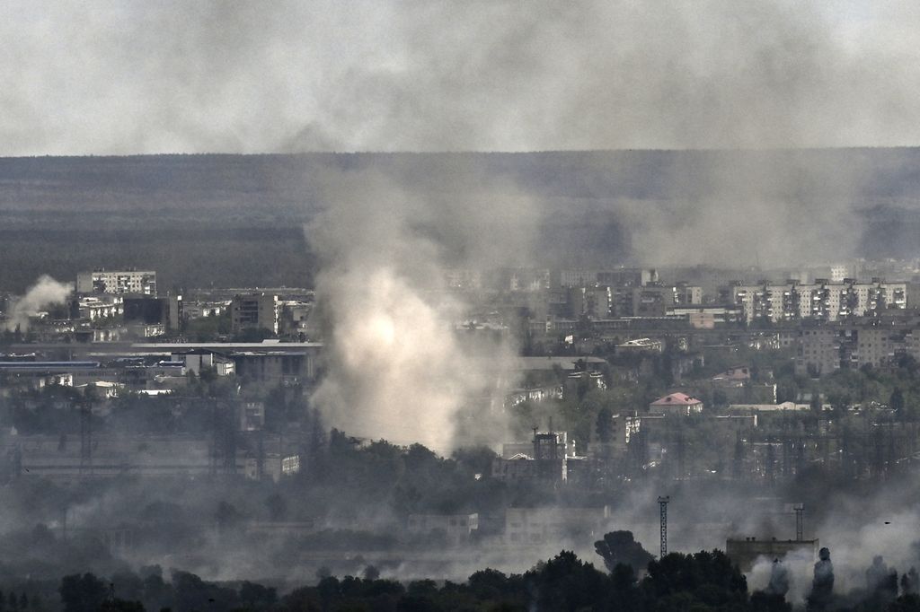 Asap mengepul dari Kota Sievierodonetsk, Selasa (7/6/2022). Militer Rusia mengklaim menguasai lebih dari 97 persen wilayah Donbas, Ukraina timur. (Photo by ARIS MESSINIS / AFP) (Photo by ARIS MESSINIS / AFP)